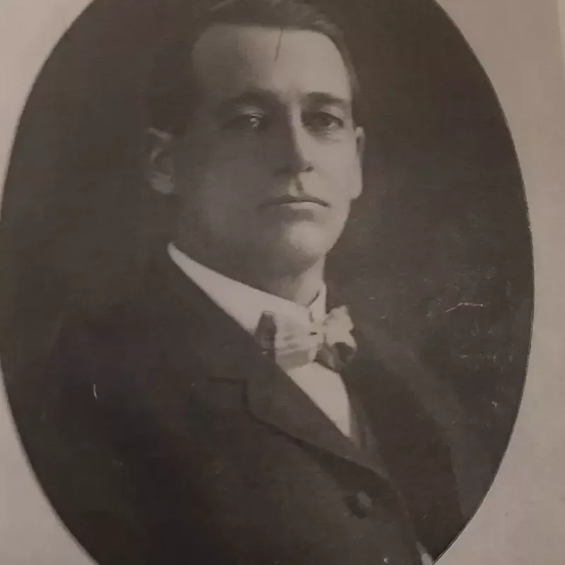 A black and white photo of a man in a suit and bow tie.