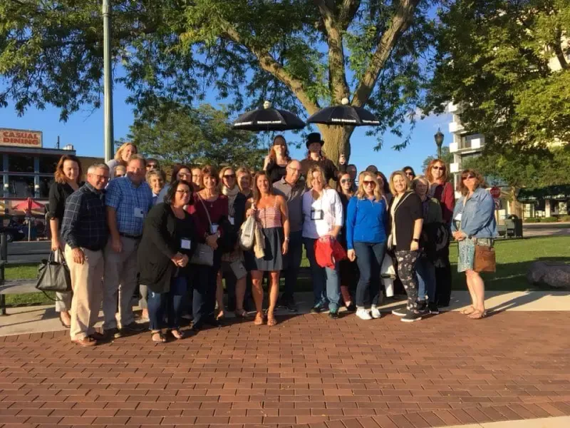 A group of people are posing for a picture in a park.