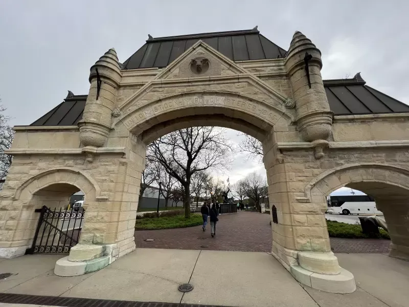 A stone archway leading to a building with a roof