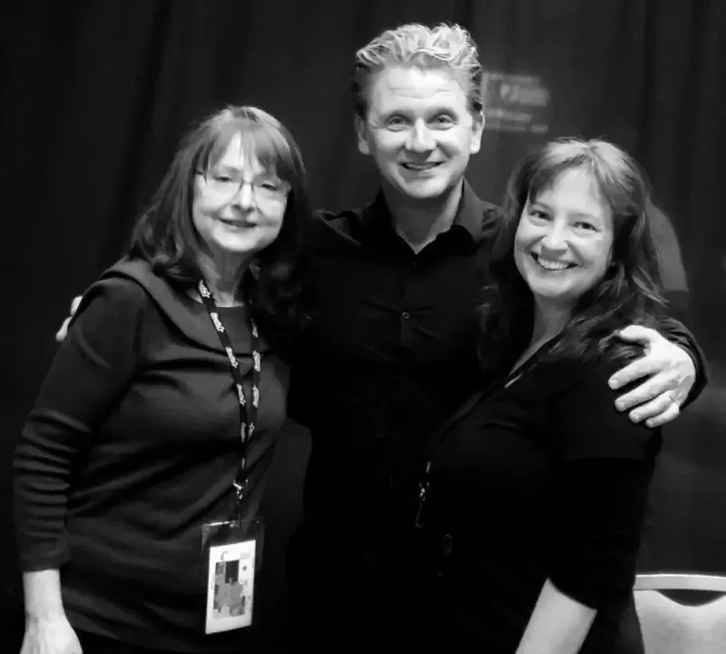 A man and two women pose for a black and white photo
