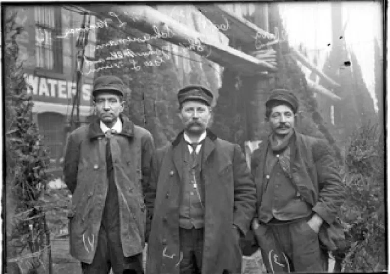 Three men are standing next to each other in a black and white photo.