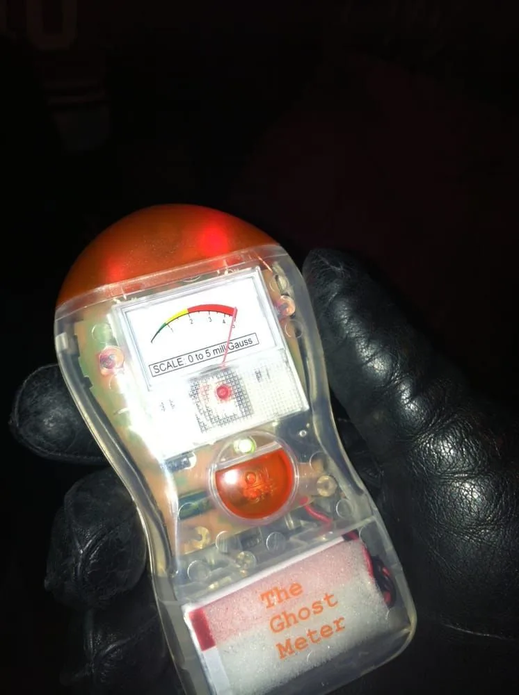 A person is holding a ghost meter in their hand