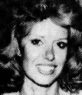 A black and white photo of a woman smiling.