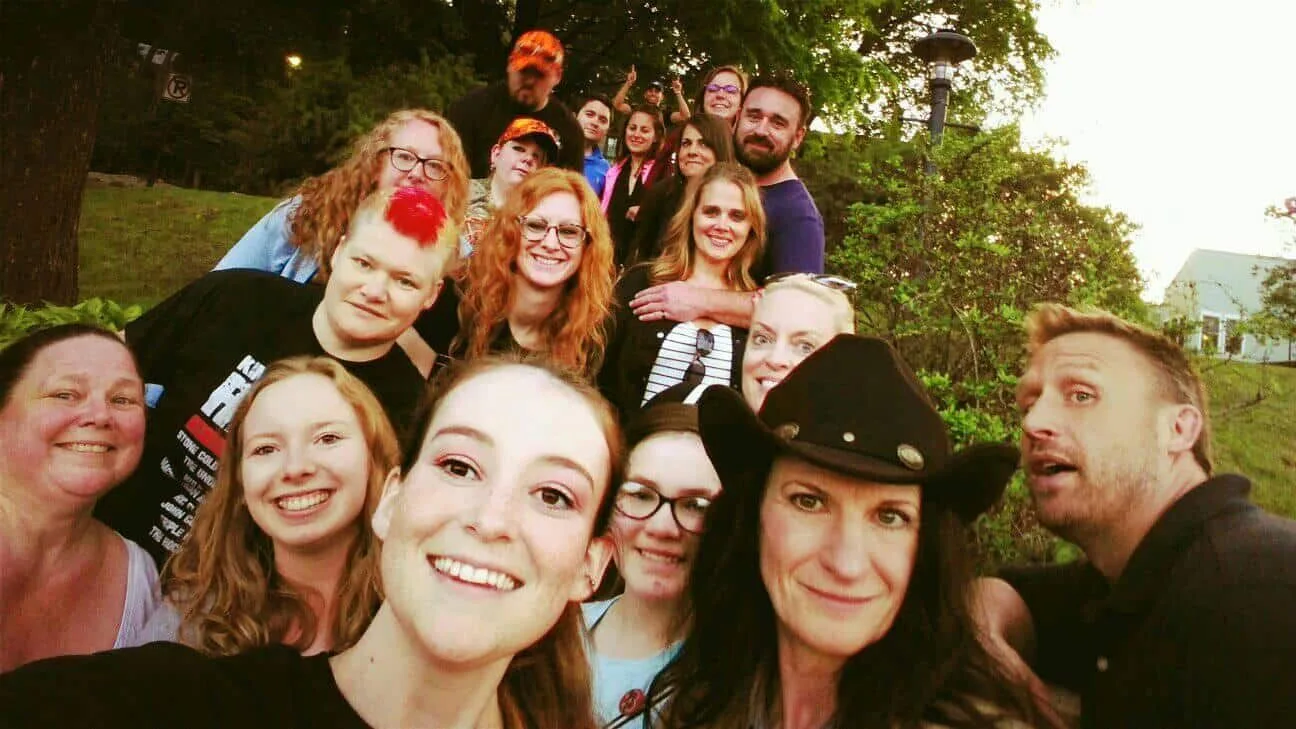 A group of people posing for a picture with one woman wearing a cowboy hat